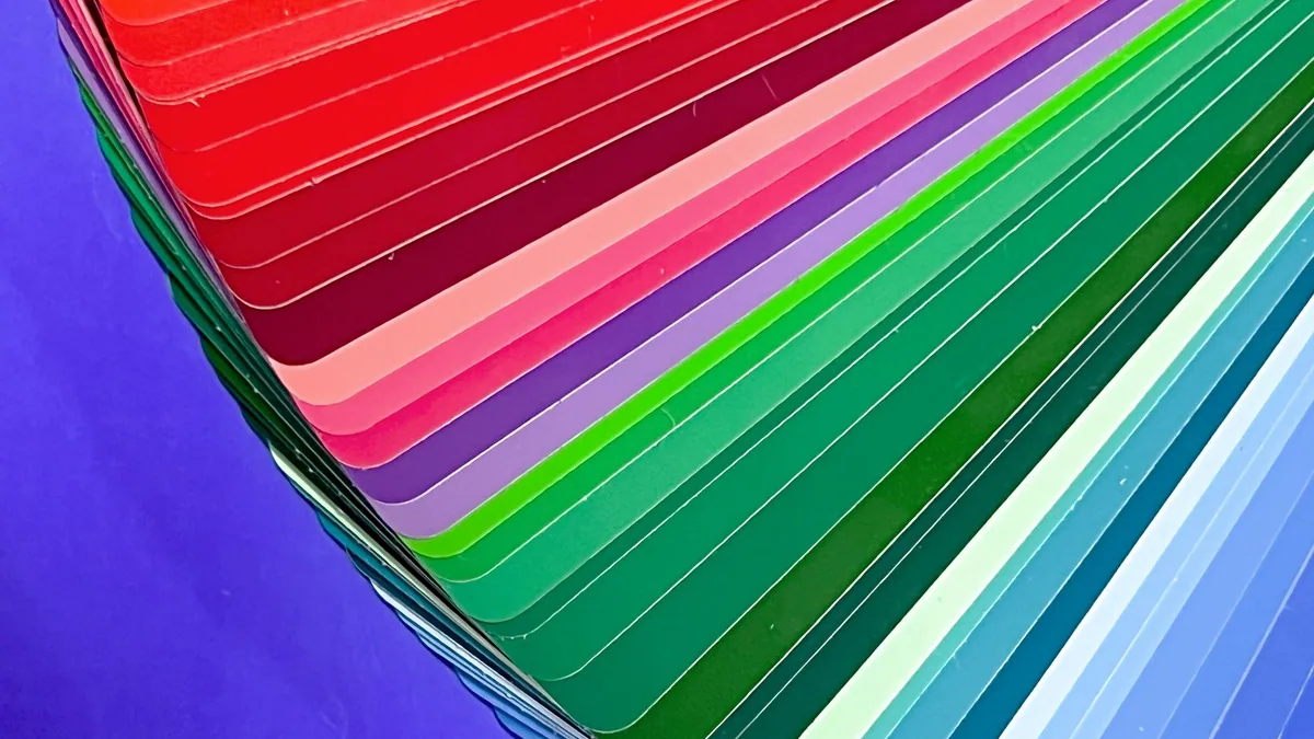 A fan deck of paint swatches, one colour picked out of many.