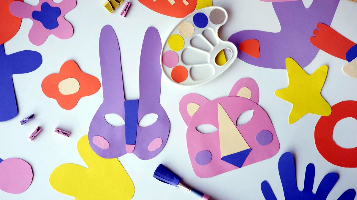 Cut paper shapes, arranged by hand: the vocabulary a vector tool works in.