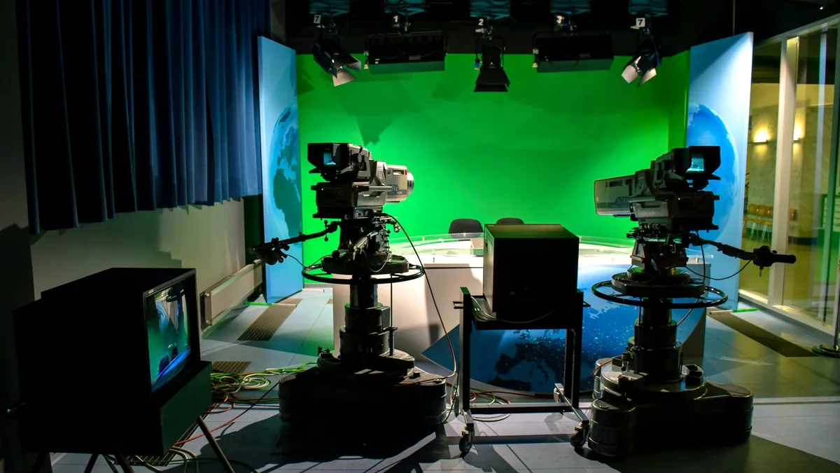 A green screen in a small studio, lit flat for keying.