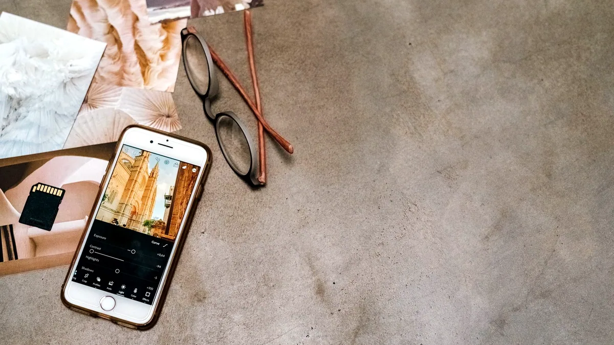 Someone editing a picture on a phone, one thumb on the slider.