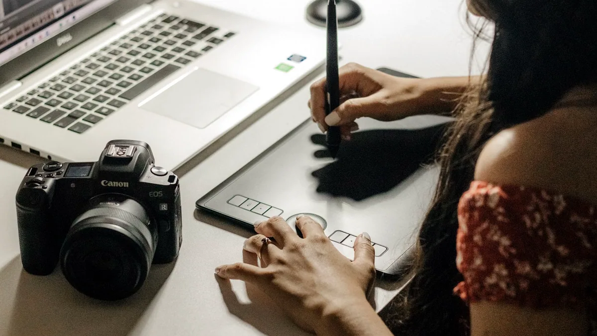 A designer at work on an image, photographed from behind the screen.